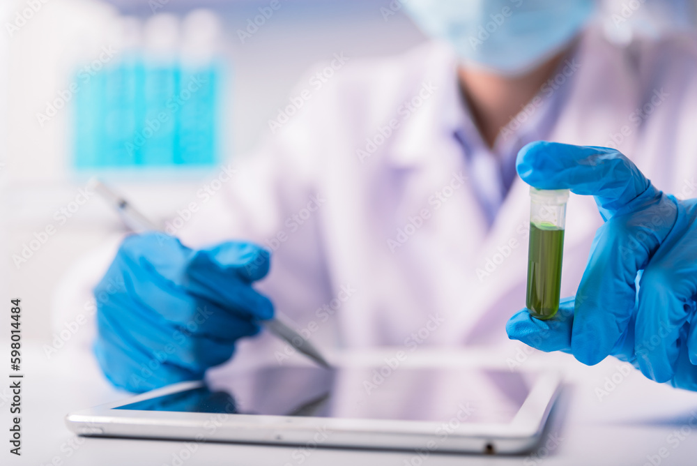 chemist,scientist record the test sample from the tube and take notes on the tablet , science research and development concept chemist,scientist record the test sample from the tube and take notes on the tablet , science research and development concept