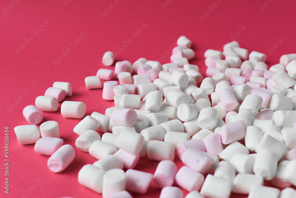 Marshmallows. Chewy sweets close-up against a pink background. Pastel tones. A copy of the text space.
