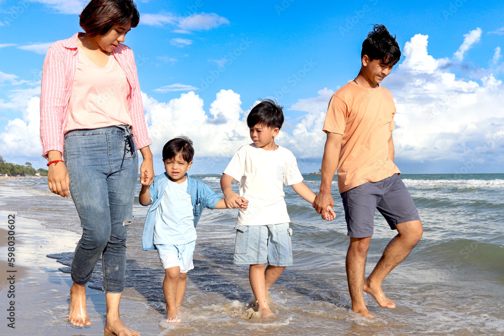 Happy family spending time together on summer holiday vacation, cheerful parents and son children kid holding hands and taking a walk on beach with blue sky, family enjoy relaxing weekend on beach. Happy family spending time together on summer holiday vacation, cheerful parents and son children kid holding hands and taking a walk on beach with blue sky, family enjoy relaxing weekend on beach.