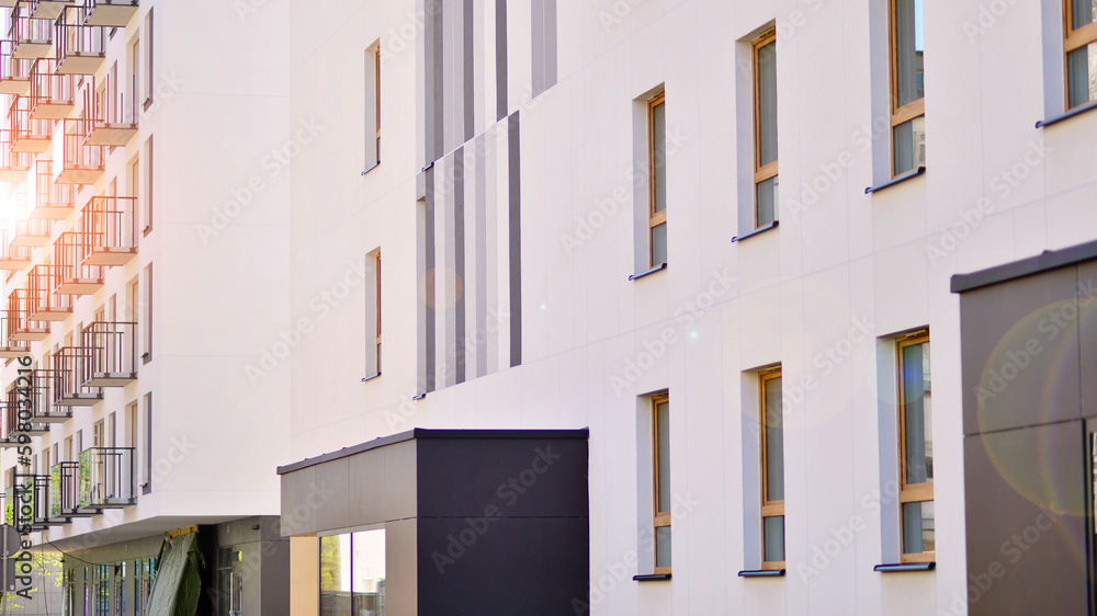 Fototapeta premium Modern apartment buildings on a sunny day with a blue sky. Facade of a modern apartment building. Contemporary residential building exterior in the daylight. 