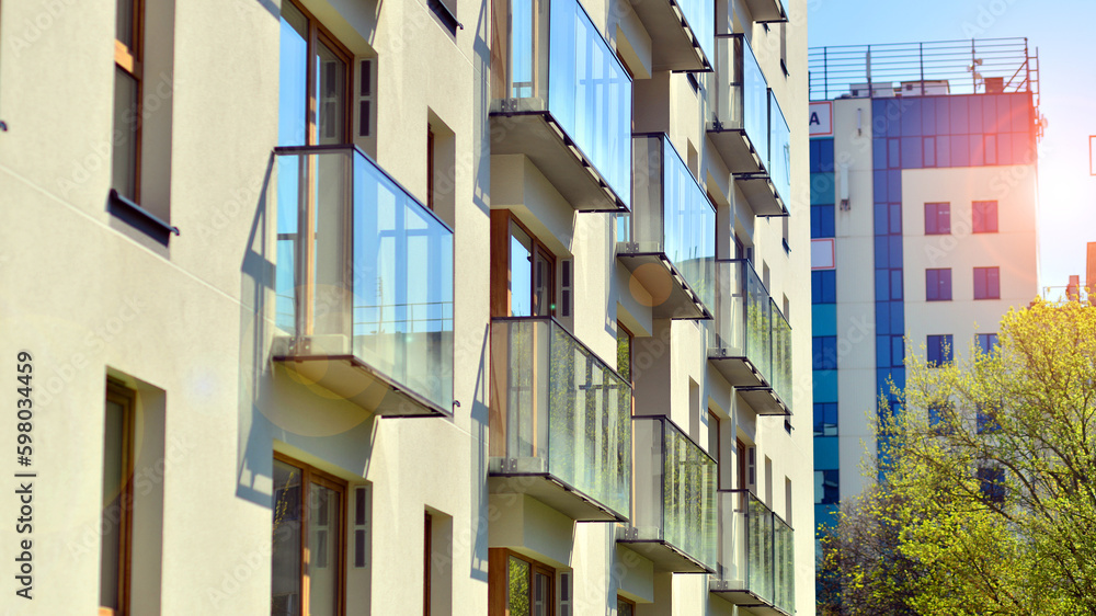 Modern apartment buildings on a sunny day with a blue sky. Facade of a modern apartment building. Contemporary residential building exterior in the daylight. Modern apartment buildings on a sunny day with a blue sky. Facade of a modern apartment building. Contemporary residential building exterior in the daylight.