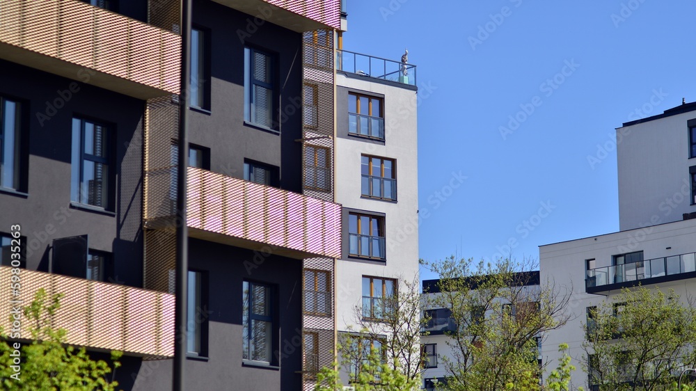 Modern apartment buildings on a sunny day with a blue sky. Facade of a modern apartment building. Contemporary residential building exterior in the daylight. Modern apartment buildings on a sunny day with a blue sky. Facade of a modern apartment building. Contemporary residential building exterior in the daylight.