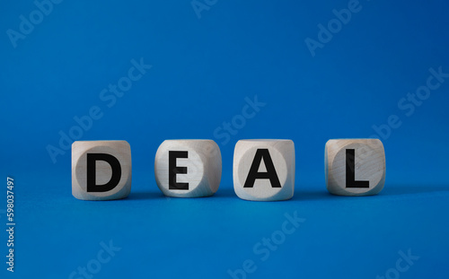 Deal symbol. Concept word Deal on wooden cubes. Beautiful blue background. Business and Deal concept. Copy space.