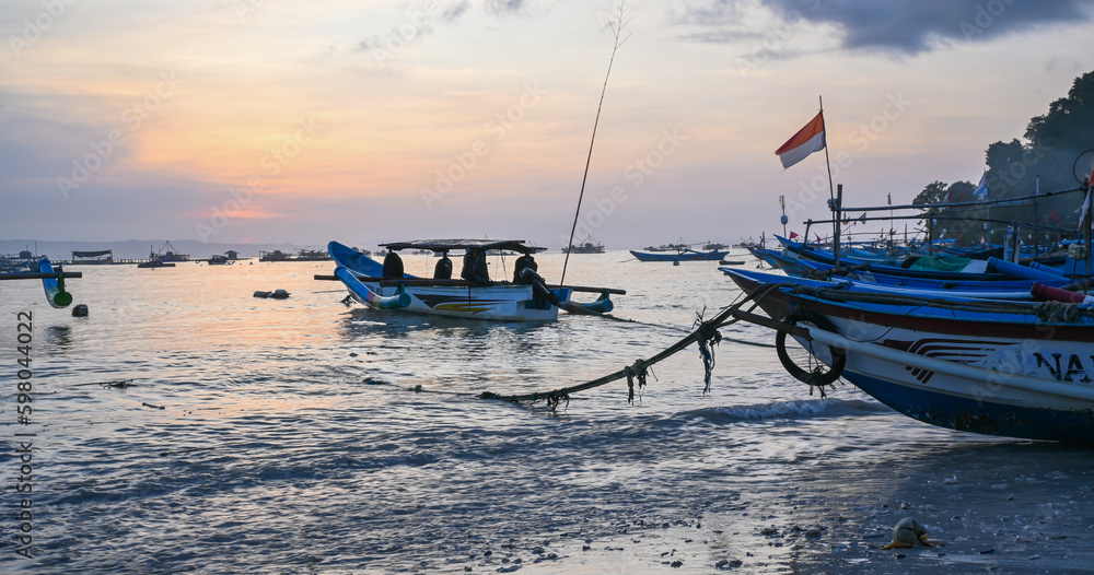 Sunrise on Indonesian Pangandaran beach with white sand and fishing boats Sunrise on Indonesian Pangandaran beach with white sand and fishing boats
