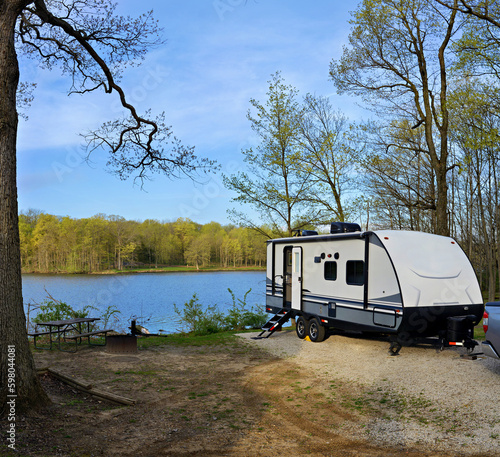 Fototapeta Travel trailer camping in the forest by the lake at Moraine View State Park, ill