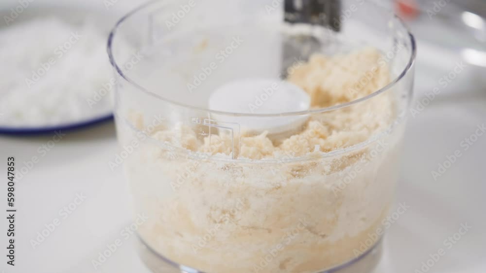 Mixing ingredients in a food processor to prepare homemade coconut cookies. Generative AI Mixing ingredients in a food processor to prepare homemade coconut cookies. Generative AI