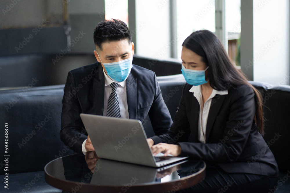 Two business colleagues at meeting in modern office interior. Businessman and businesswoman discussing work and using laptop computer in meeting indoors. Two business colleagues at meeting in modern office interior. Businessman and businesswoman discussing work and using laptop computer in meeting indoors.