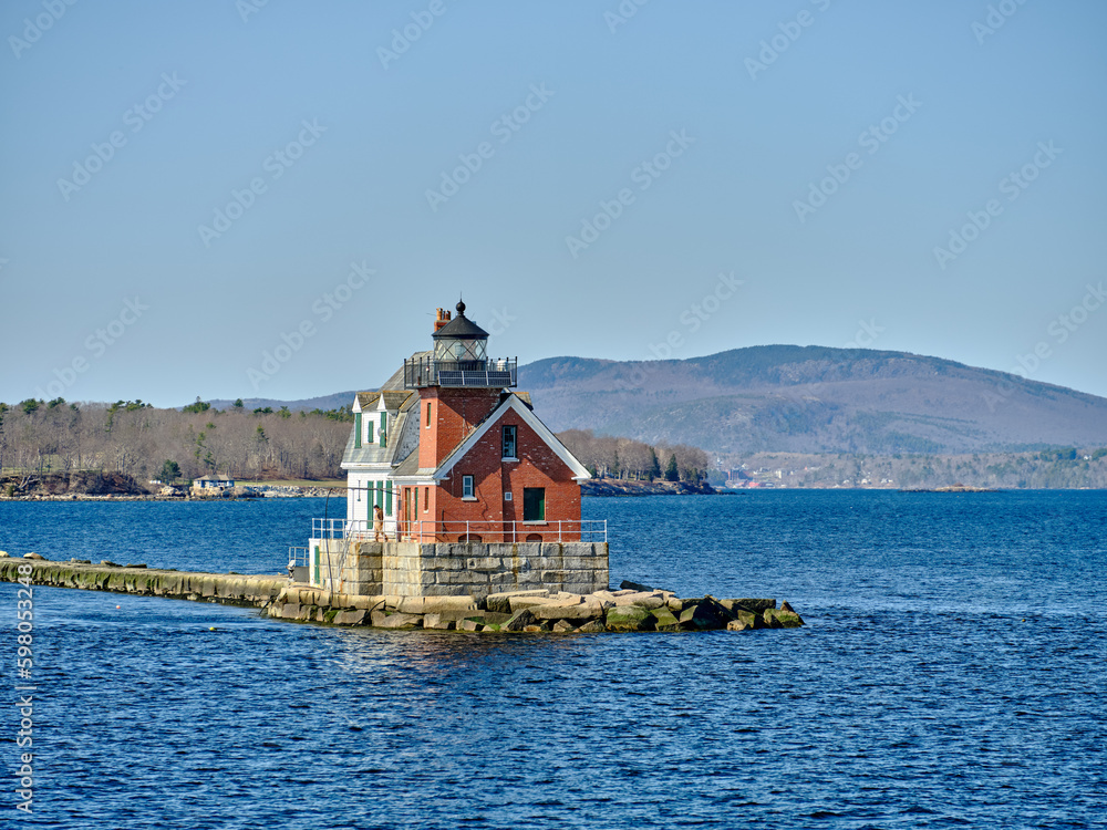 The Rockland Breakwater Lighthouse as seen from the ferry heading back into Rockland harbor with the town of Rockland maine in the background The Rockland Breakwater Lighthouse as seen from the ferry heading back into Rockland harbor with the town of Rockland maine in the background