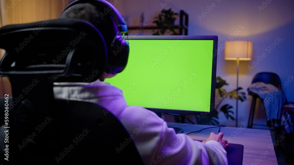 Young gamer plays game looking at monitor with chromakey Young gamer plays game looking at monitor with chromakey