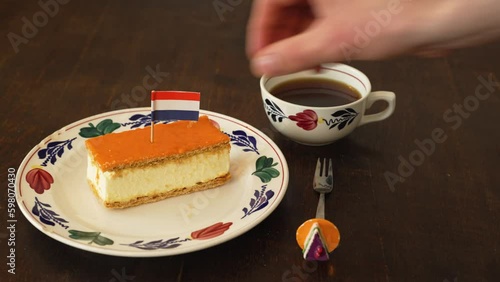 Decorating orange tompouce with dutch flag, typical dutch pastry eaten especially around King's Day national holiday photo