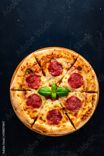 Circle pepperoni pizza with mozzarella cheese on wooden table 
