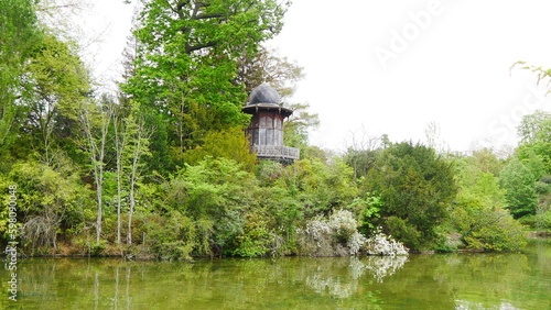 Tour ou petit monument d'observation ou de prière, au bois de Boulogne, forêt parisien, avec grand lac propre, limpide et pleine de verdure, avec des arbres partout et un peu de rochers photo