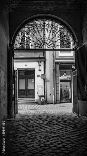 Bielsko-Biala one of the many streets A monochrome photo of a grand architectural entrance illuminated by light against the darkness, framed in black and white.