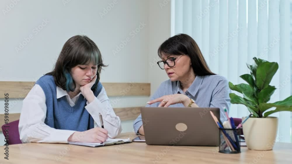 College student girl sitting with female teacher studying individually in class College student girl sitting with female teacher studying individually in class