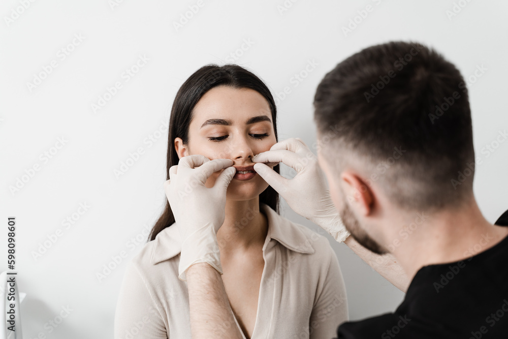 Cheiloplasty lip reconstruction is surgical procedure to modify the appearance or function of the lips. Bullhorn surgery. Surgeon touches lips of patient before cheiloplasty. Cheiloplasty lip reconstruction is surgical procedure to modify the appearance or function of the lips. Bullhorn surgery. Surgeon touches lips of patient before cheiloplasty.