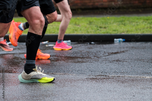 Group of people running London Marathon. Only we can see legs.