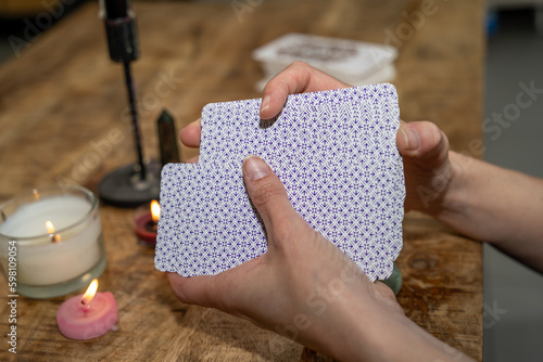 Mains d'une cartomancienne qui bat des cartes avant un tirage photo