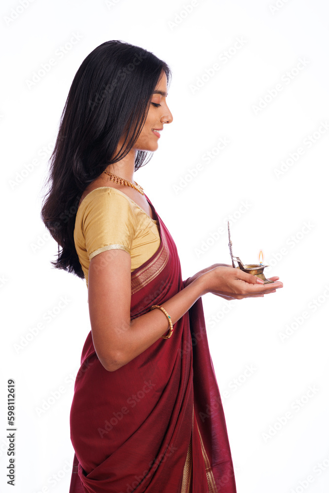 Beautiful happy Indian young woman in saree holding Deepa (oil lamp ) isolated on white. Beautiful happy Indian young woman in saree holding Deepa (oil lamp ) isolated on white.