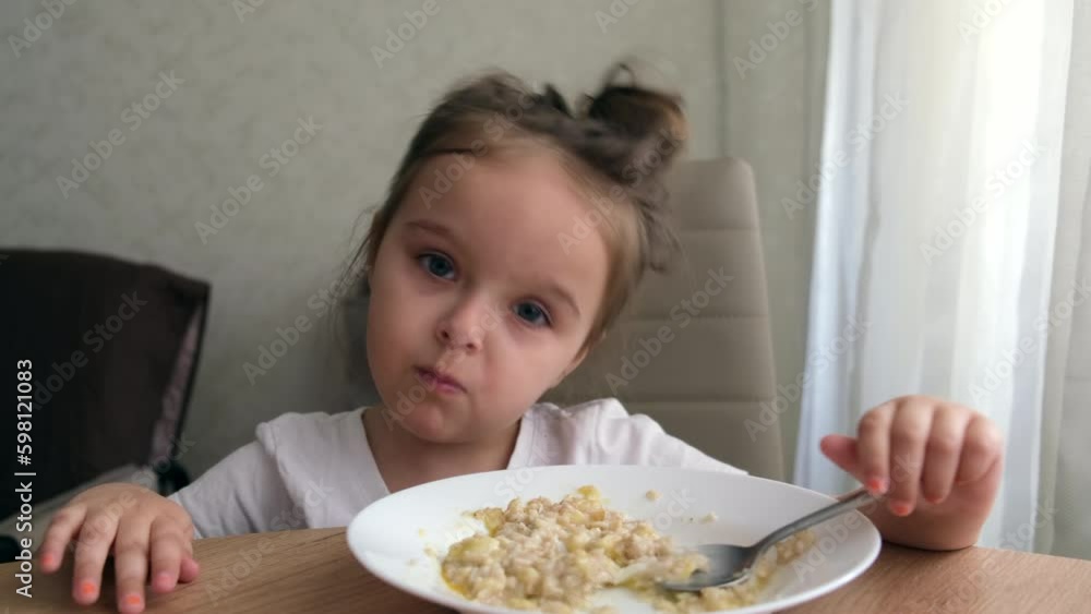 Cute little girl of 4 eats porridge. Cute little girl of 4 eats porridge.