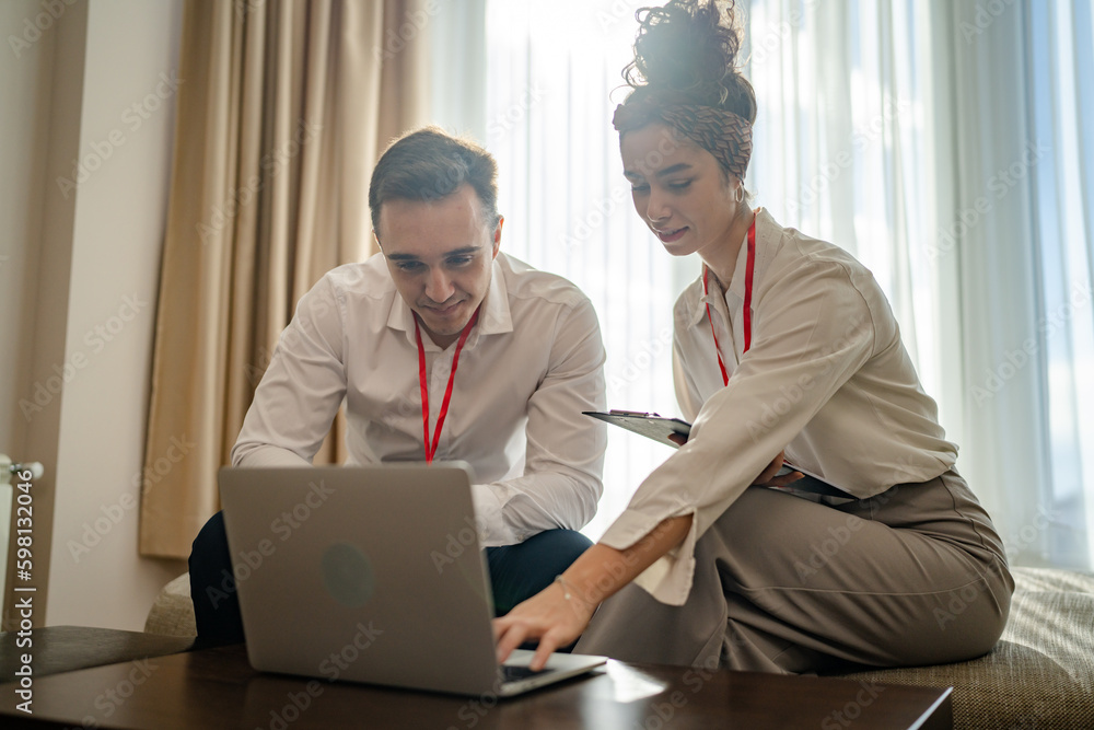 Obraz premium man and woman colleagues sit together in hotel room prepare for work