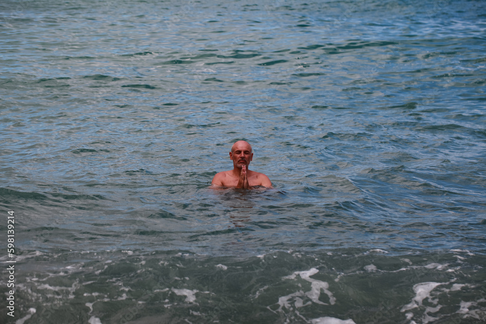 Portrait of a bald man swimming in the sea on a sunny day