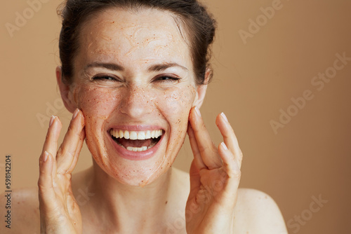Portrait of smiling modern woman with face scrub photo