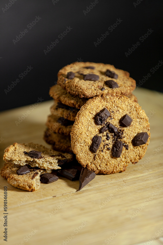 Handmade cookies for a healthy breakfast. Homemade oatmeal cookies with dark chocolate on a dark background.