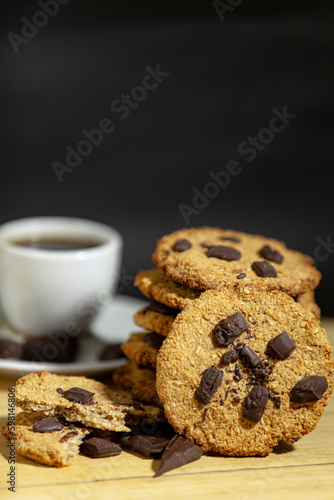 Handmade cookies for a healthy breakfast. Homemade oatmeal cookies with dark chocolate on a dark background.