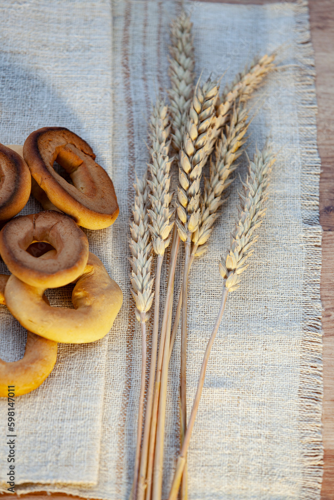 Homemade baking. Dry bagels on a napkin against the background of spikelets of wheat