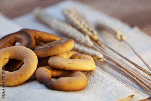 Obraz na płótnie Homemade baking. Dry bagels on a napkin against the background of spikelets of wheat w salonie