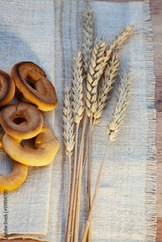 Obraz na płótnie Homemade baking. Dry bagels on a napkin against the background of spikelets of wheat w salonie