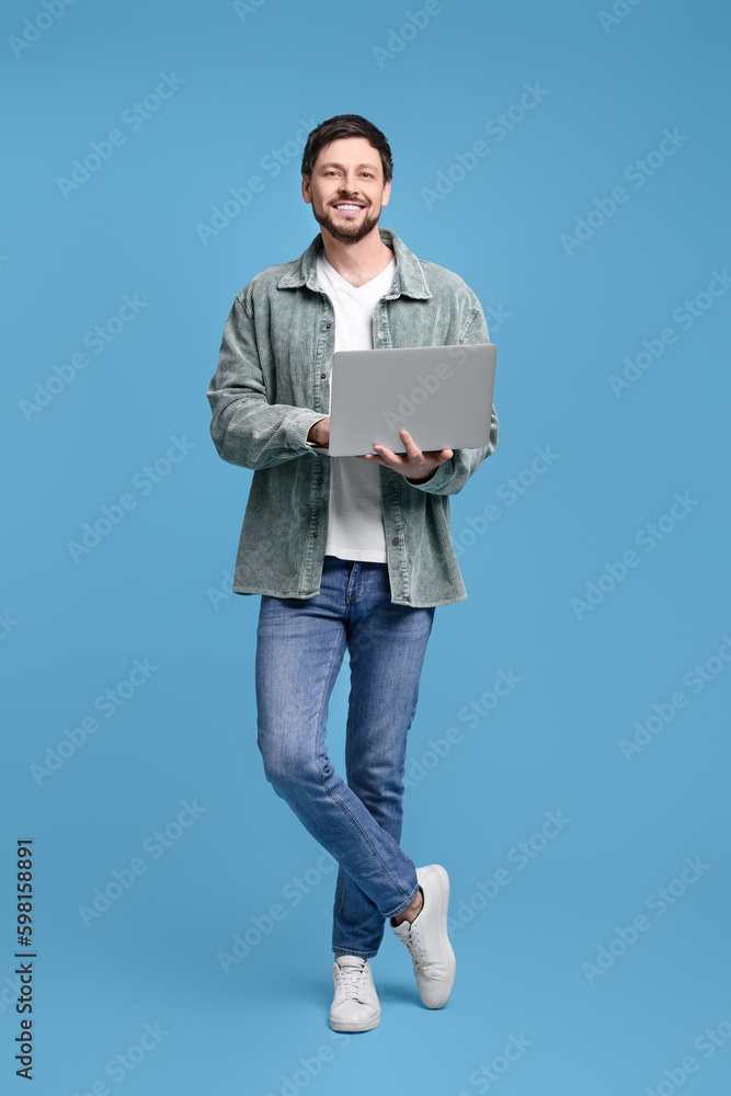 Happy man with laptop on light blue background Happy man with laptop on light blue background