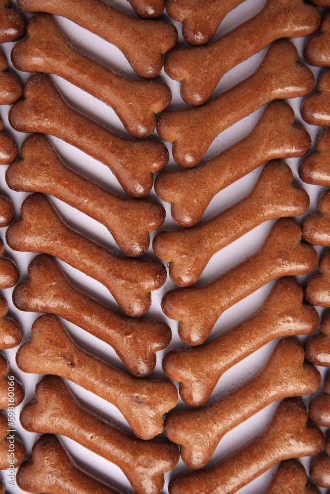 Flat lay composition with many bone shaped dog cookies on white background