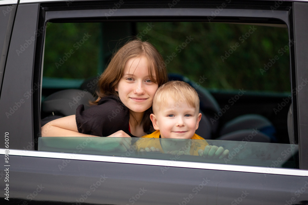 Happy brother and sister looking out car window. Happy brother and sister looking out car window.