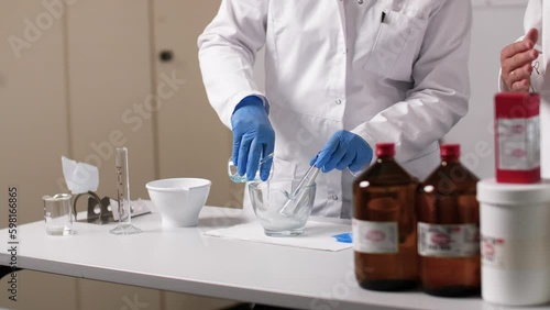 A liquid is filled in a glass bowl. The PTA wears gloves and the environment is sterile. photo