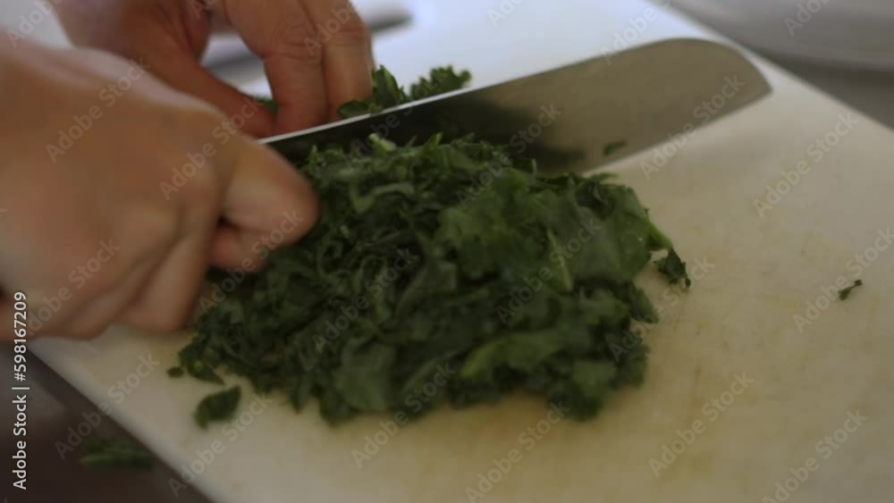 Chef chopping green vegetables on a cutting board. Chef chopping green vegetables on a cutting board.