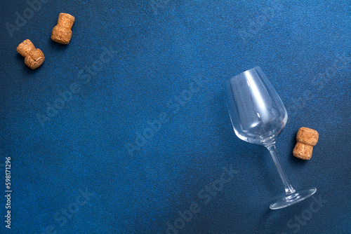 Glass empty glass and wine corks . on a blue background