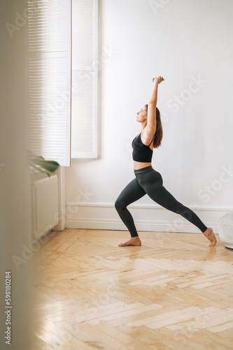 Young slim woman in sportwear doing fitness exercises, girl dancing at bright studio
