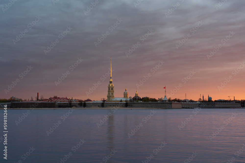 View of the Peter and Paul Fortress and the Neva River against a pink dawn sky with clouds on a sunny spring morning, St. Petersburg, Russia