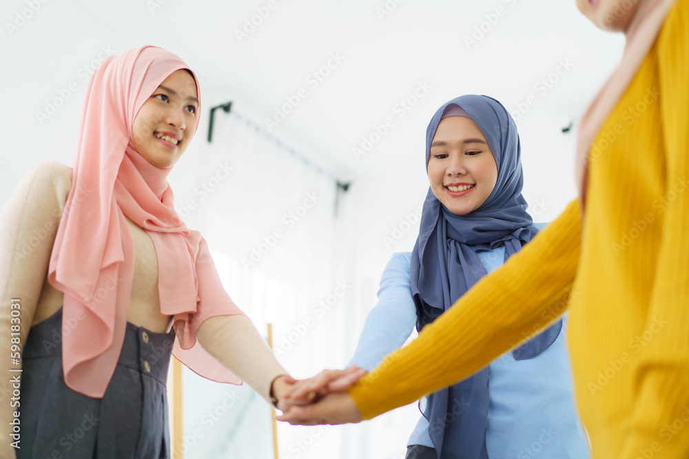 Group of a beautiful smart Asian muslim woman standing in the room and having a discussion together. 