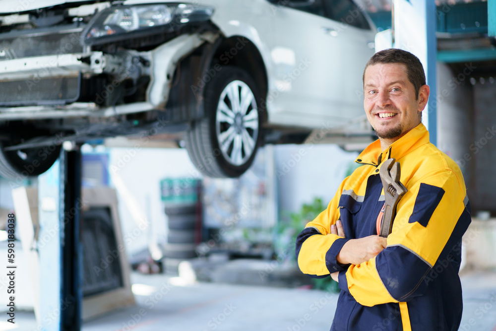 Professional caucasian white automobile technician holding a wrench and making crossed arms and looking at camera. Professional caucasian white automobile technician holding a wrench and making crossed arms and looking at camera.
