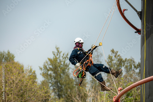 Focus male swing rope worker down height tank roof rope access safety inspection of thickness storage tank