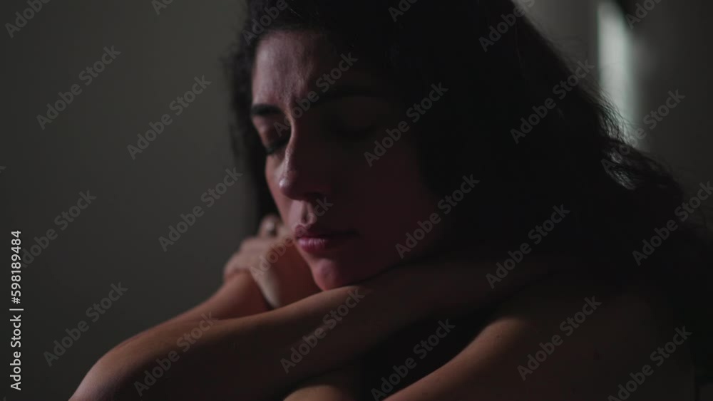 Fragile young woman struggling with mental illness in her room. Female person in 30s feeling lonely and alone while suffering from depression Fragile young woman struggling with mental illness in her room. Female person in 30s feeling lonely and alone while suffering from depression