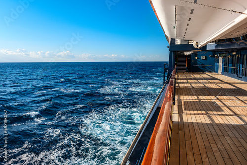 View of open deck of the cruise ship sailing in sea and waves and blue sky background