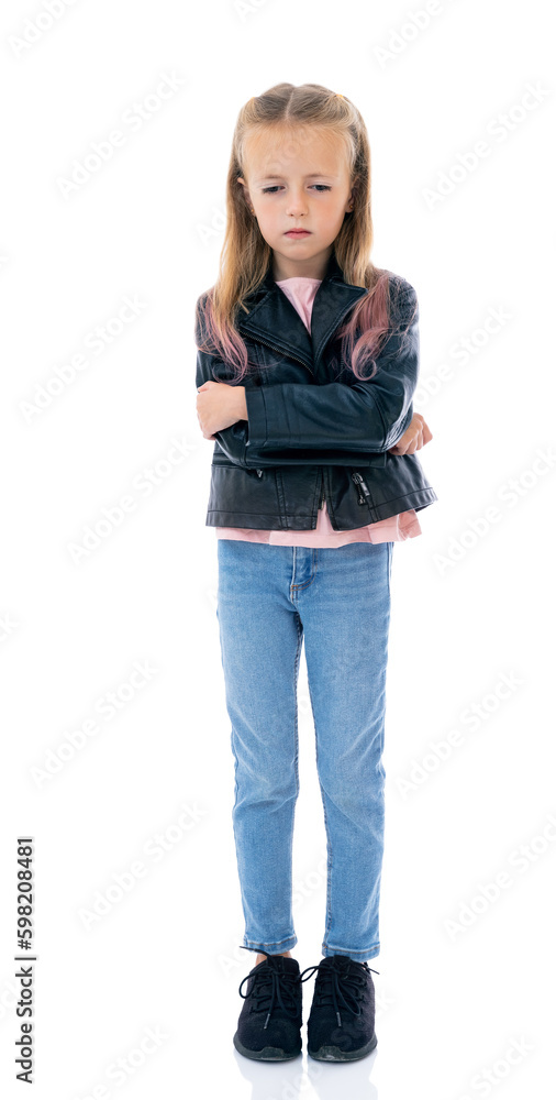 Full-length portrait of dissatisfied five year old girl with arms crossed over looks down, isolated on white background. Small girl with irritated face in black leather jacket posing in studio. Full-length portrait of dissatisfied five year old girl with arms crossed over looks down, isolated on white background. Small girl with irritated face in black leather jacket posing in studio.