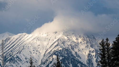snowy mountain peaks in the clouds. cloudy weather in the mountains. snow cliffs. beautiful clouds © Daniil_98_03_09