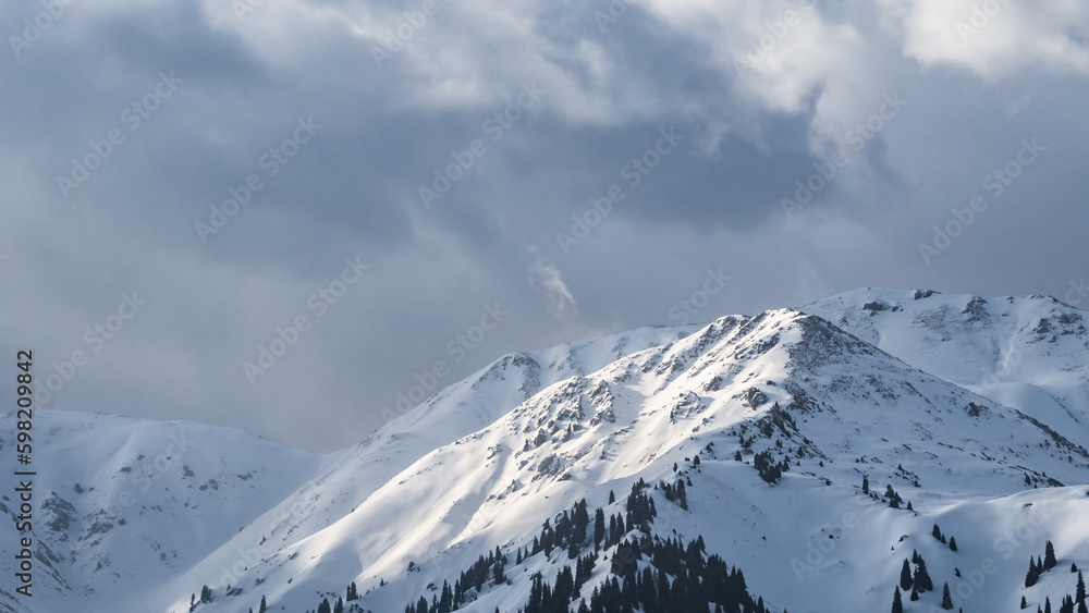 snowy mountain peaks in the clouds. cloudy weather in the mountains. snow cliffs. beautiful clouds