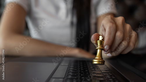 Woman playing chess, Woman hand holds chess piece on dark background, Hand business woman moving chess for business challenge.