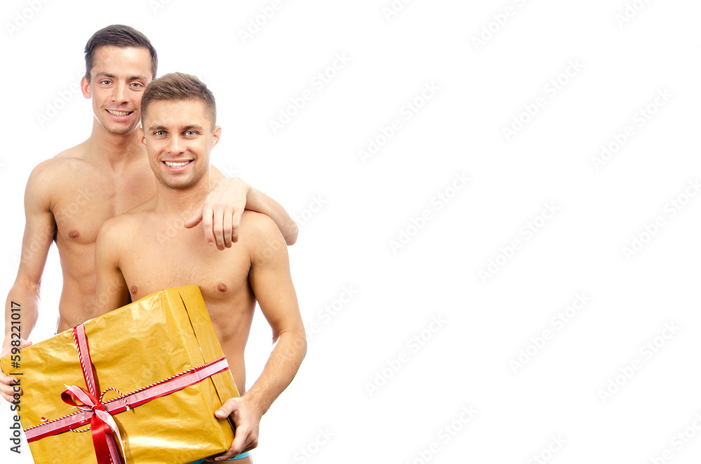 Two young attractive guys are posing in the studio. Beautiful gay couple in a relationship on holidays with gifts. Love and romance. Two young attractive guys are posing in the studio. Beautiful gay couple in a relationship on holidays with gifts. Love and romance.