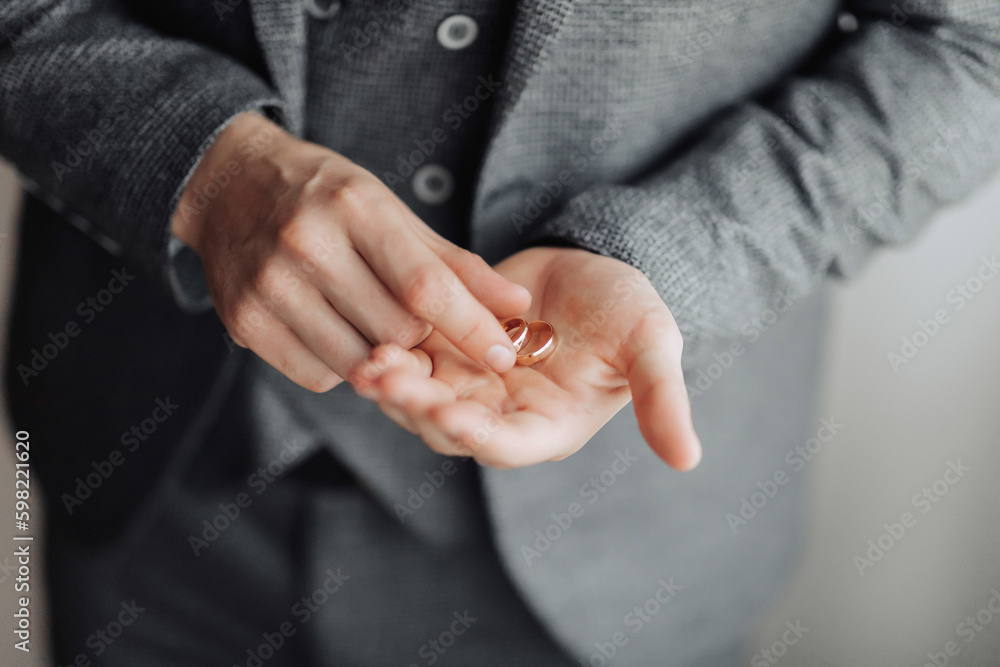 Photo of wedding rings that lie beautifully on the groom's hands. A beautiful photo with details of the wedding. Wedding day. Daylight. A stylish man. Beautiful hands